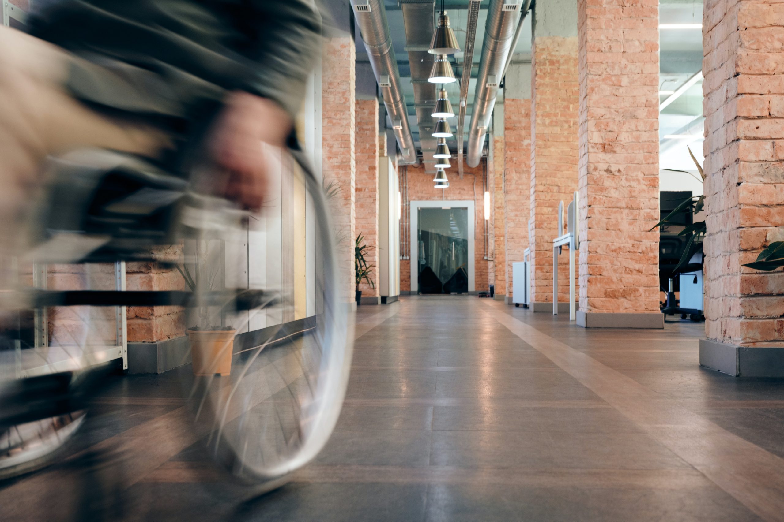 Woman in wheelchair rolling down hallway.