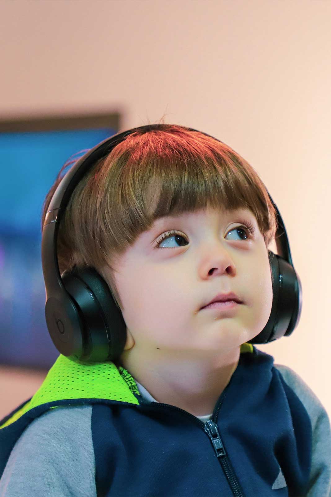 Young boy wearing over-ear headphones.